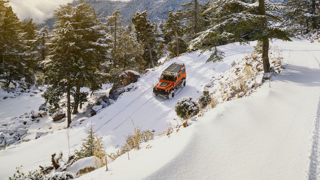 Essential winter camping gear. Overlander vehicle driving snow covered track. I Go Overland Blog.