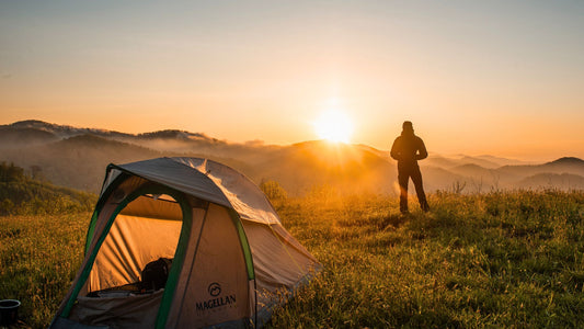 Minimalist overlanding. Man standing next to tent admiring sunset. I Go Overland Blog